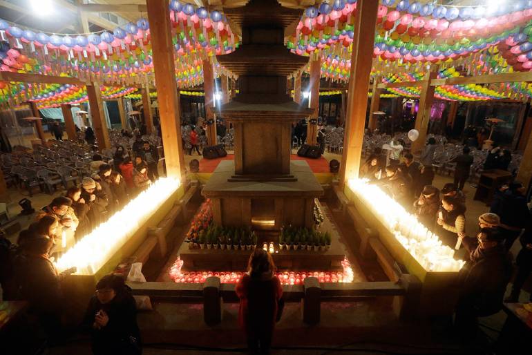 พุทธศาสนิกชนในเกาหลีใต้มาสวดมนต์ไหว้พระ ที่วัดบงกึน ในกรุงโซล เนื่องในวันขึ้นปีใหม่ (ภาพ: AP)